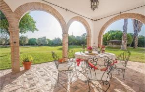 patio ze stołem, krzesłami i polem w obiekcie Gorgeous Home In La Campana, Sevilla w mieście La Campana