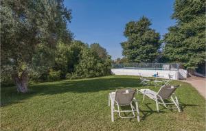dwa krzesła i stół na dziedzińcu w obiekcie Gorgeous Home In La Campana, Sevilla w mieście La Campana +25 zdjęć