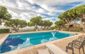 uma piscina com duas cadeiras e árvores em Amazing Home In Cabrils With 4 Bedrooms, Wifi And Outdoor Swimming Pool em Cambrils