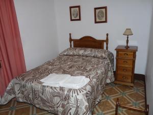 1 dormitorio con cama y tocador de madera en CASA RURAL QUIJOTE Y SANCHO en Argamasilla de Alba