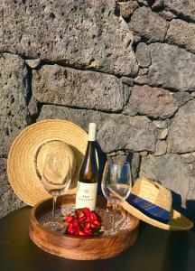 uma garrafa de vinho e dois copos numa mesa em Adega da Prainha em Prainha de Baixo