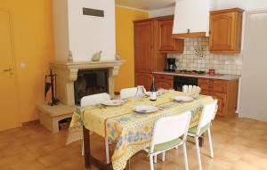kuchnia ze stołem z krzesłami i kominkiem w obiekcie 2 Bedroom Gorgeous Home In Visan w mieście Visan