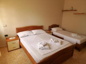 1 dormitorio con 2 camas y toallas. en Apartament Orion, en Vlorë