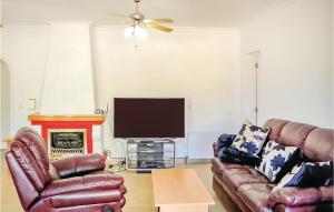 un soggiorno con 2 divani in pelle e una TV a schermo piatto di Awesome Home In Rojales With Kitchen a Rojales