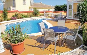 un patio con tavolo e sedie accanto alla piscina di Awesome Home In Rojales With Kitchen a Rojales