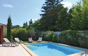 a swimming pool with two lawn chairs and a fence at Nice Home In Ancone With 3 Bedrooms, Private Swimming Pool And Outdoor Swimming Pool in Ancône