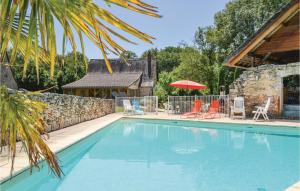 a swimming pool with chairs and a stone wall at 2 Bedroom Awesome Home In Padirac in Padirac