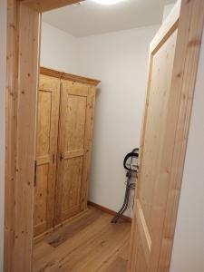een lege kamer met een houten kast en een deur bij Ferienwohnung Maintalblick in Mainleus