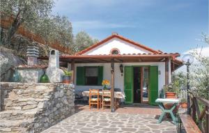 ein kleines Haus mit grünen Türen und einer Steinmauer in der Unterkunft San Michele in Buti