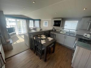a kitchen with a table and chairs in a room at Lakeside Retreat 3 with hot tub, private fishing peg situated at Tattershall Lakes Country Park in Tattershall