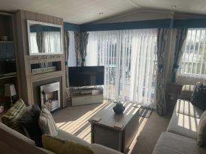 a living room with a television and a fireplace at Lakeside Retreat 3 with hot tub, private fishing peg situated at Tattershall Lakes Country Park in Tattershall