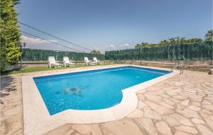 マサネッド・ダ・ラ・セルバにあるBeautiful Home In Macanet De La Selva With 3 Bedrooms, Wifi And Outdoor Swimming Poolのスイミングプール(椅子2脚、テーブル付)
