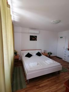 a bedroom with a white bed with black pillows at Apartments Grebović in Dubrovnik