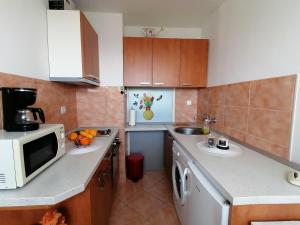 a small kitchen with a microwave and a sink at Apartments Grebović in Dubrovnik