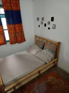 a small bed in a room with a window at Karibu Nyumbani, Welcome Home in Mwanza