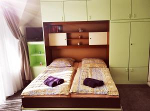 2 camas en un dormitorio con armarios verdes en Haus am Binnensee, en Fehmarn