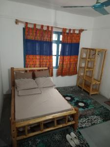 a bedroom with a bed and two shelves and a window at Karibu Nyumbani, Welcome Home in Mwanza