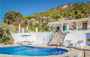 a villa with a swimming pool and a house at Nice Home In Frigiliana With 2 Bedrooms, Wifi And Outdoor Swimming Pool in Frigiliana
