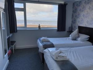 a hotel room with two beds with a view of the beach at Balmoral in Morecambe