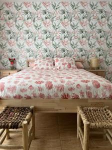 1 dormitorio con 1 cama y papel pintado con motivos florales en La Habana Apart Hotel en Lloret de Mar