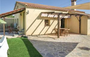 un patio con tavolo, sedie e una casa di Stunning Home In Villanueva Del Duque a Villanueva del Duque