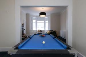 a living room with a pool table in the middle at Rossmay House - 4 Bedroom Scottish Villa with waterfront / mountain views in Arrochar