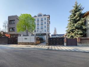 una puerta frente a un edificio con un árbol en GREGORY Boutique Hotel Chisinau en Chisináu