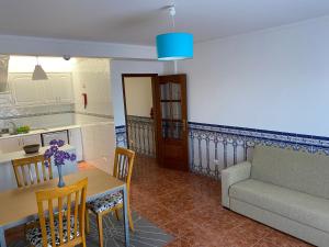 eine Küche und ein Wohnzimmer mit einem Tisch und einem Sofa in der Unterkunft Ericeira Sand Beach F7 in Ericeira + 2 Fotos