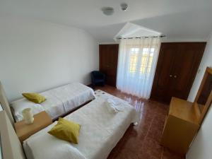 Cette chambre comprend 2 lits et une fenêtre. dans l'établissement Ericeira Sand Beach F7, à Ericeira