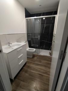 een badkamer met een toilet, een wastafel en een douche bij Apartamento Manuela, totalmente nuevo, 8 km de la playa in Llanes