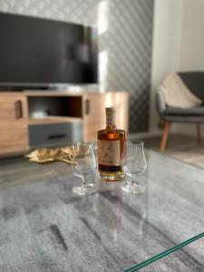 - une bouteille de whisky et deux verres à vin sur une table dans l'établissement Vidus Apartman Kaposvár, à Kaposvár