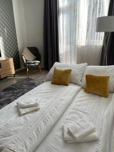 Cette chambre comprend un grand lit blanc et une fenêtre. dans l'établissement Vidus Apartman Kaposvár, à Kaposvár