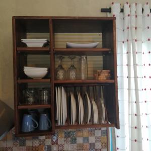 una estantería de madera con platos y platos. en Eco Moyano Posada, en Gaucín