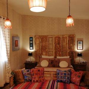 a bedroom with a bed and two lamps and a couch at Eco Moyano Posada in Gaucín