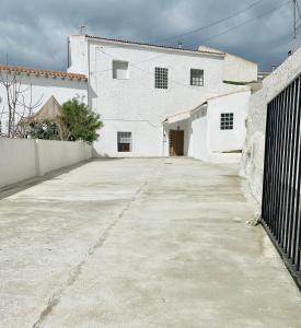 a large white building with a concrete driveway at Cueva de Ramón y Elvira in Cuevas del Campo