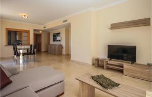 a living room with a couch and a flat screen tv at Stunning Apartment In Benahavs With Swimming Pool in Estepona