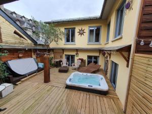 un cortile con vasca idromassaggio su una terrazza in legno di Le Patio de Luchon a Luchon