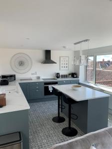 a kitchen with blue cabinets and a table in it at 'The View' Penthouse Apartment Number Four Lees Terrace in Holt