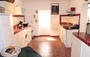 a kitchen with white cabinets and a tile floor at Stunning Home In Reillanne With Wifi in Reillanne