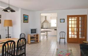 Saint-Quay-PerrosにあるStunning Home In Saint Quay Perros With 4 Bedroomsのリビングルーム、キッチン(テーブル、椅子付)