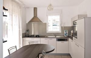 een keuken met een houten tafel en een wastafel bij 4 Bedroom Pet Friendly Home In Saint Quay Perros in Saint-Quay-Perros