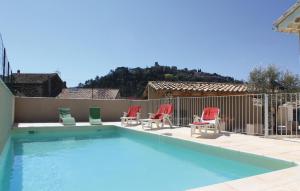 a swimming pool with four chairs and a fence at Awesome Home In Saint Thome With 5 Bedrooms, Wifi And Outdoor Swimming Pool in Saint-Thomé