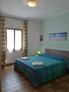 a bedroom with a bed with two towels on it at Casa GiovanMarco con vista mare in Santa Teresa Gallura
