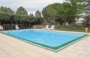 uma grande piscina num quintal com cadeiras e árvores em Beautiful Home In Puisserguier With 3 Bedrooms, Wifi And Outdoor Swimming Pool em Puisserguier