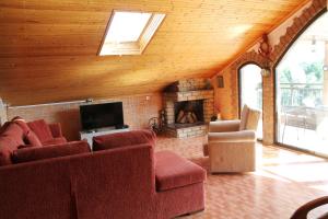 a living room with red chairs and a fireplace at Ourania luxury apartment in Keramotí