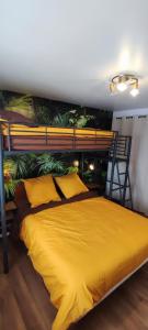 ein Schlafzimmer mit einem gelben Bett und einem Wandbild in der Unterkunft Nature et vue in Ménétru-le-Vignoble