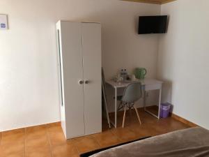un armario blanco en una habitación con una mesa en LCC rooms, en Couço