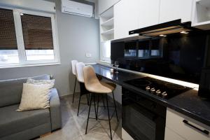 une cuisine avec un comptoir noir et un canapé dans l'établissement Minimalist Design Apartament in Magheru, à Bucarest