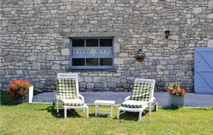 two chairs and a table in front of a stone building at Pet Friendly Home In Belvèze With Wifi in Valprionde
