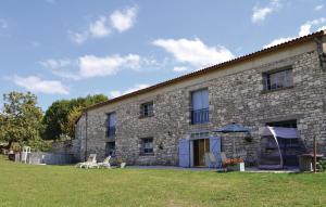 a stone building with two chairs and an umbrella at Pet Friendly Home In Belvèze With Wifi in Valprionde